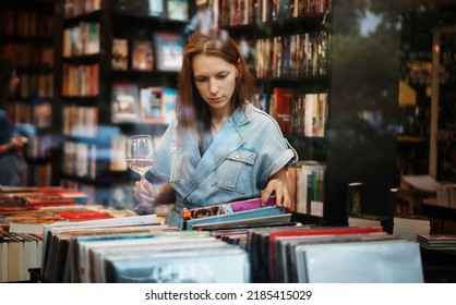 Young Beautiful Woman Looking At Vinyl Records In Bookstore