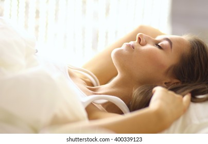Young beautiful woman lying in bed - Shutterstock ID 400339123