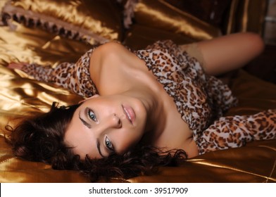 Young beautiful woman lying on a bed in a luxury hotel room