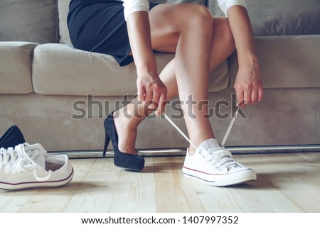 Young beautiful woman makes the choice between comfortable and uncomfortable shoes. Beautiful or comfortable shoes concept