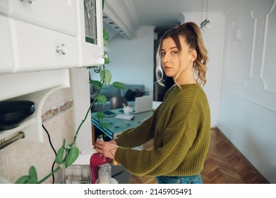 Young Beautiful Woman Making Fresh Espresso Coffee On The Machine In A Kitchen At Home. Barista Coffee Maker At Home. Coffee Machine Making Coffee.