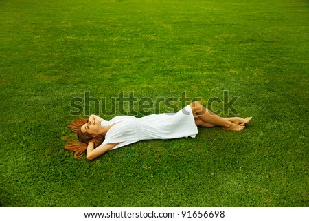 Young beautiful woman  on the green grass