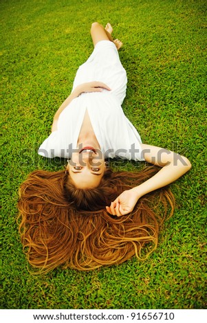 Young beautiful woman on the green grass