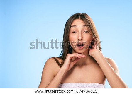 Young beautiful woman on a light blue background, portrait, emotions.