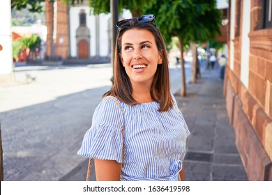 Junge schöne Frau im romantischen Dorf, die an einem sonnigen Tag auf der Stadtstraße spazieren geht