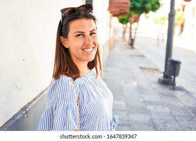 Junge schöne Frau im romantischen Dorf, die an einem sonnigen Tag auf der Stadtstraße spazieren geht