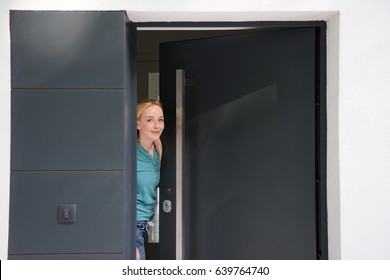 young beautiful woman opening her house door to welcome people - Powered by Shutterstock