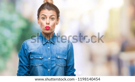 Young beautiful woman over isolated background puffing cheeks with funny face. Mouth inflated with air, crazy expression.