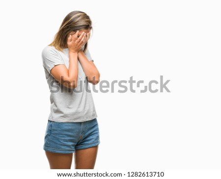 Young beautiful woman over isolated background with sad expression covering face with hands while crying. Depression concept.