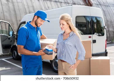 young beautiful woman paying for delivery with card - Powered by Shutterstock