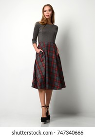 Young Beautiful Woman Posing In New Fashion Plaid Skirt And Gray Full Body On A White Background