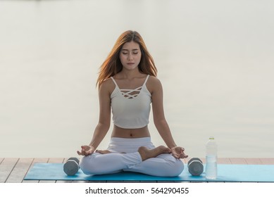 Young Beautiful Woman Practice Mindfulness Meditation After Fitness Exercise To Restore Harmony And Health Also To Calm  Mind And Improve Mood .