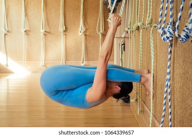 young and beautiful woman practicing yoga kurunta. stretching the arms, back and spine ( yoga kurunta )