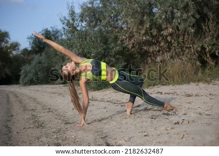 Young beautiful woman practicing yoga on the beach. Wellness concept. Yoga asanas