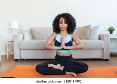 Young beautiful woman in the prayer position. Woman practicing yoga, relaxing in prayer position on mat, Padmasana exercise girl wearing sportswear working out, meditating in yoga studio or at home
