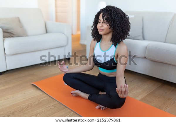 Young beautiful woman in the prayer position. Woman\
practicing yoga, relaxing in prayer position on mat, Padmasana\
exercise girl wearing sportswear working out, meditating in yoga\
studio or at home