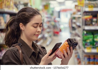 Young Beautiful Woman Reads Product Information Via QR Code.