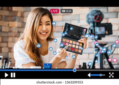 Young beautiful woman recording live stream video for makeup and cosmetics business purpose online with video player interface amd full of positive feedbacks
