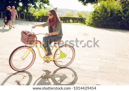 Young beautiful woman riding a bicycle in a park. Active people.
