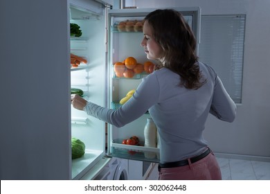 Young Beautiful Woman Searching For Food In The Fridge