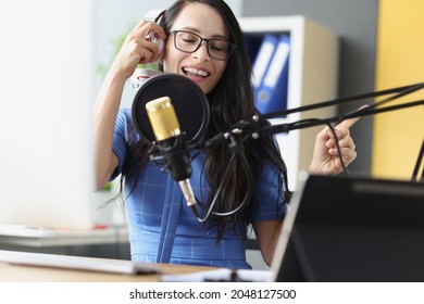 Young Beautiful Woman Singing Into Microphone With Headphones