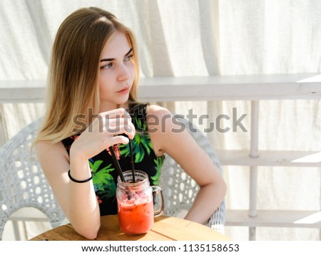 Young beautiful woman sipping fresh cold fruitshake