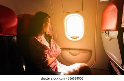 Young Beautiful Woman Sit By Window Of Airplane During Flight