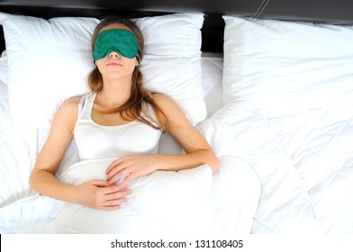 Young Beautiful Woman Sleeping In Bed With Eye Mask