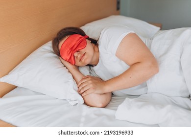 Young Beautiful Woman Sleeping In Bed With Pink Eye Mask. Millennial Caucasian Girl Sleeping On Soft Pillow, Enjoying Sweet Dreams Good Night Rest In Bed.