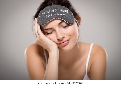 Young Beautiful Woman Sleeping With Eye Mask On Grey Background. Portrait Of Brunette Tired Girl With Eye Mask For Sleeping. Sleepy Beauty Woman Resting On Hand With Closed Eyes.