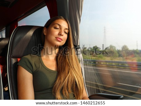 Young beautiful woman sleeping sitting in the bus. Bus passenger traveling sitting in a seat and sleeping.