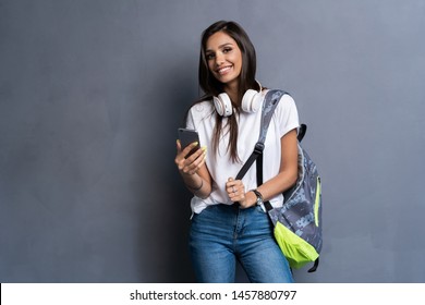 Young Beautiful Woman With Smart Phone. Smiling Student Girl Going On A Travel. Isolated On Gray Background