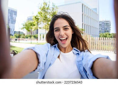 Young beautiful woman smiling Taking selfie photo at university campus. Trendy girl in casual attire. Positive cheerful female student posing outdoors for sharing in social media app. Caucasian lady