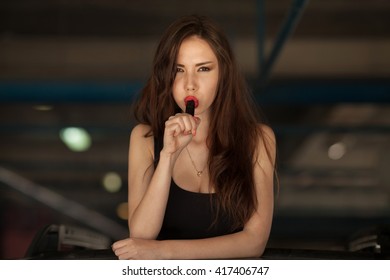 Young beautiful woman smoking ( vaping ) e-cigarette with smoke in car luke