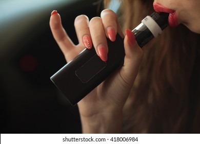 Young beautiful woman smoking ( vaping ) e-cigarette with smoke