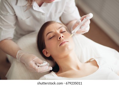 The young beautiful woman in a spa receiving facial treatment injections.