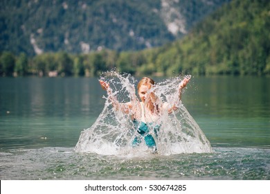 Young beautiful woman splashing in lake and looking through water. Recreation and healthy lifestyle concept - Powered by Shutterstock