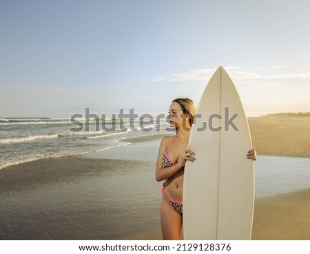 Similar – Young surfer woman with top and bikini holding surfboard