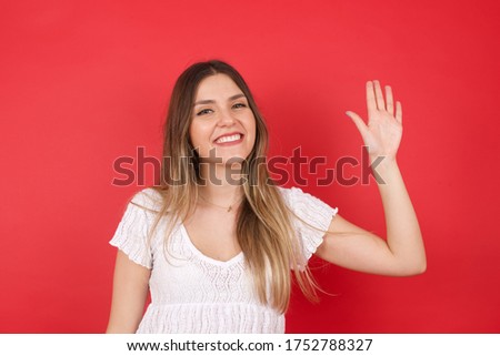 Young beautiful woman standing over yellow isolated background Waiving saying hello or goodbye happy and smiling, friendly welcome gesture