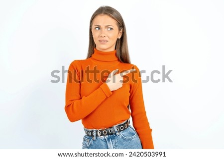 Young beautiful woman standing over white studio background Pointing aside worried and nervous with forefinger, concern and surprise concept.