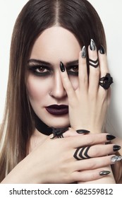 Young beautiful woman with stylish gothic make-up and manicure