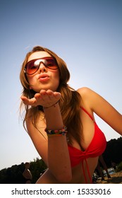 Young Beautiful Woman In Sunglasses Blow A Kiss To You.