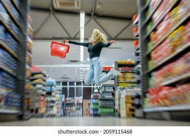 Young Beautiful Woman In A Supermarket Wearing Protective Face Mask While Grocery Shopping With A Shopping Basket And Jumping