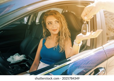 young and beautiful woman take the key from valet to drive her car