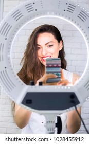 Young And Beautiful Woman Taking Selfie Picture With Mobile Phone In Light Of The Ring Lamp