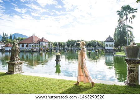 Young beautiful woman in Taman Ujung water palace, Bali island, Indonesia - Travel blogger exploring Water Palace in Bali