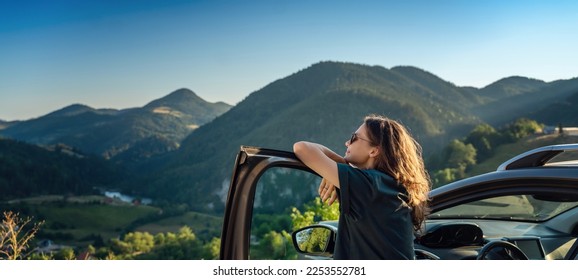 Young beautiful woman traveling by car in the mountains, summer vacation and adventure