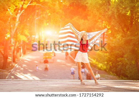 Young beautiful woman with usa flag in nature. Happy USA Flag Day. Independence Day USA. End of quarantine.