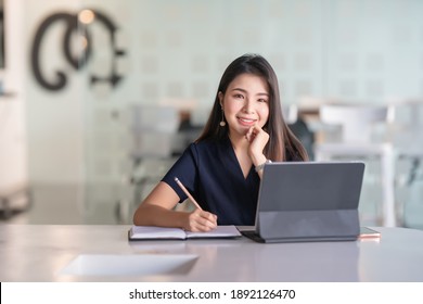 Young beautiful woman using her laptop while sitting in a chair at her working place. - Shutterstock ID 1892126470
