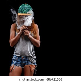 Young beautiful woman is vaping an e-cigarette